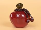 a red apple with a beaded necklace on it