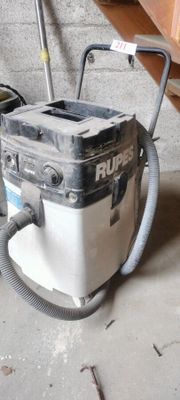 a vacuum that is sitting on the floor next to a trash can