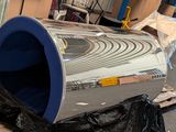 un gros objet métallique posé sur une palette dans un entrepôt