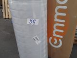 un grand rouleau de tissu blanc à côté d'une boîte en carton