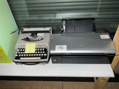 une machine à écrire posée sur un bureau, à côté d'une imprimante