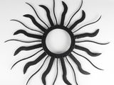 a black metal sunburst hanging on a wall