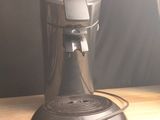 une cafetière posée sur une table en bois près d'une fenêtre