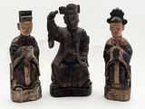 trois figurines en bois représentant des personnages asiatiques sur un fond blanc