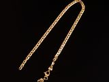 un collier plaqué or avec une chaîne sur fond noir