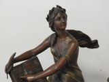 a bronze statue of a woman holding a book