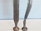 Il s'agit de deux objets métalliques d'aspect très ancien posés sur une table.