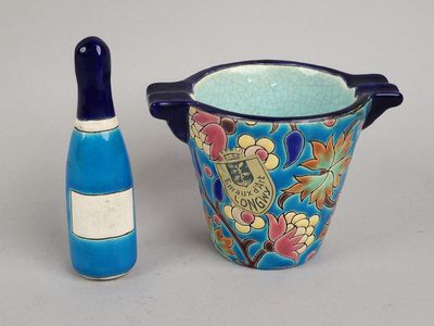 un vase bleu et une bouteille de vin placés l'un à côté de l'autre