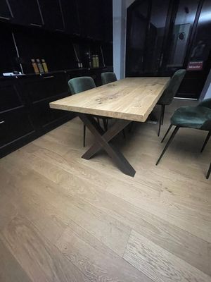 une table et des chaises en bois dans une pièce équipée d'armoires noires