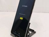 a close up of a cell phone on a stand on a white surface
