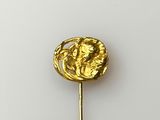 a gold brooch on a stick with a picture of a man