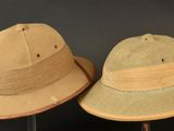 two hats are sitting on top of each other on a stand