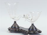 two glass vases sitting on top of a metal stand