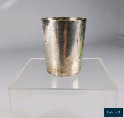 une coupe en argent posée sur un socle transparent