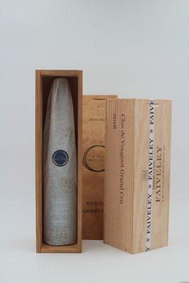 une bouteille de vin dans un coffret en bois, à côté d'une boîte