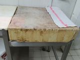 a dirty table in the kitchen with a dirty cloth on top of it