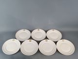 six white plates are stacked on top of each other on a table