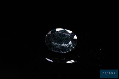 a close up of a black diamond on a black surface
