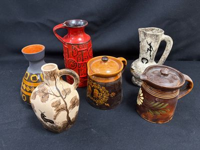 de nombreux vases de styles variés posés sur un fond noir