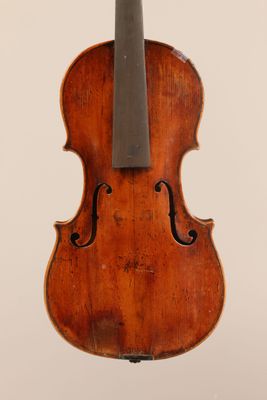 an old violin with a bow hanging from the back