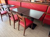 tables and chairs in a restaurant with red booths
