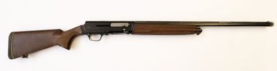 un fusil posé sur une surface blanche, muni d'une crosse en bois
