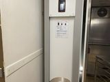 un réfrigérateur blanc dans une cuisine, à côté d'un plan de travail en inox
