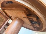 a wooden table with a circular top and a wooden base