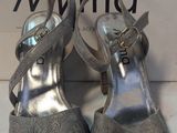 Les chaussures argentées de la femme se trouvent sur la boîte, à côté de celle-ci.