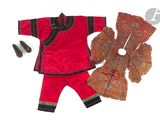 une poupée qui porte une tenue rouge et une paire de chaussures