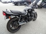 a black motorcycle parked in a parking lot next to other cars