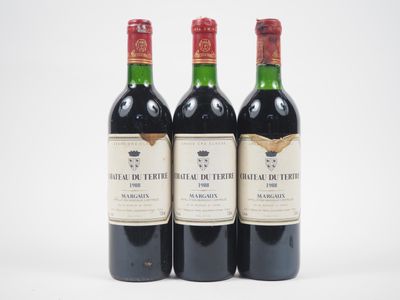 trois bouteilles de vin rouge posées l'une à côté de l'autre sur une surface blanche