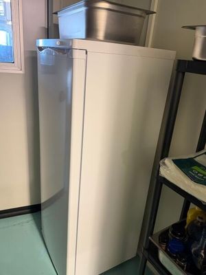 un réfrigérateur blanc dans une petite pièce avec une fenêtre