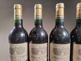 four bottles of wine are lined up on a table