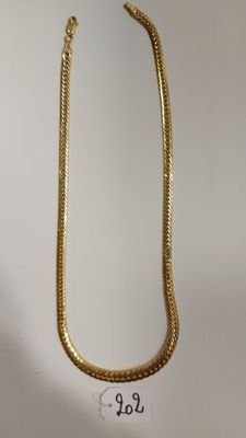un collier en or sur fond blanc, avec une étiquette de prix