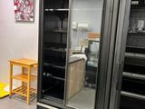 une image d'une cuisine avec un réfrigérateur et une table