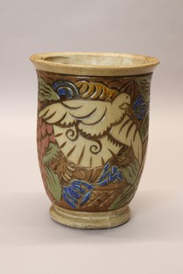 a vase with a bird on it sitting on a table