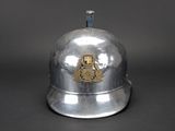 a silver bell with a gold emblem on it