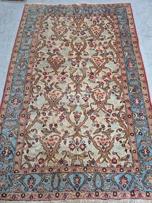 an antique persian rug with a floral design on a blue ground