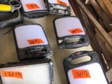 Plusieurs téléphones portables sont alignés sur une table dans un entrepôt