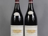 two bottles of red wine sitting on top of a table