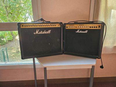 two marshall amps sitting on a table in front of a window