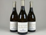 trois bouteilles de vin posées sur une table l'une à côté de l'autre