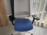 une chaise de bureau bleue et blanche dans un coin de la pièce