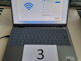 un ordinateur portable posé sur une table sur laquelle figure un numéro