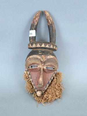 une image d'un masque en bois accroché au mur