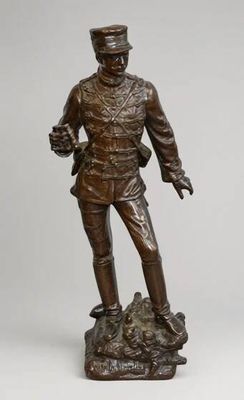 une statue en bronze représentant un homme debout au sommet d'un rocher