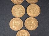 six pièces d'or sont disposées en triangle sur une surface noire