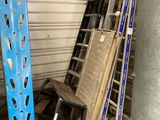 a stack of ladders next to a water heater in a garage