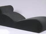 un canapé noir posé sur une surface blanche